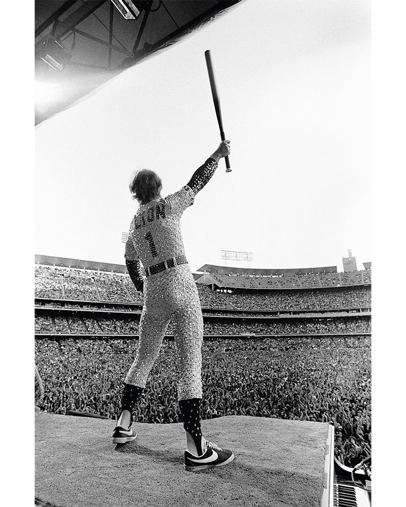 Elton John standing on a piano, 1975
