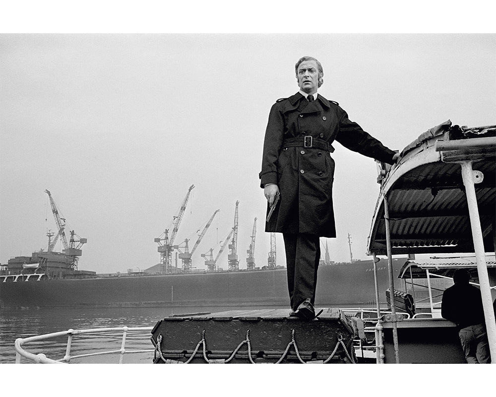 Michael Caine stands on a boat, 1970